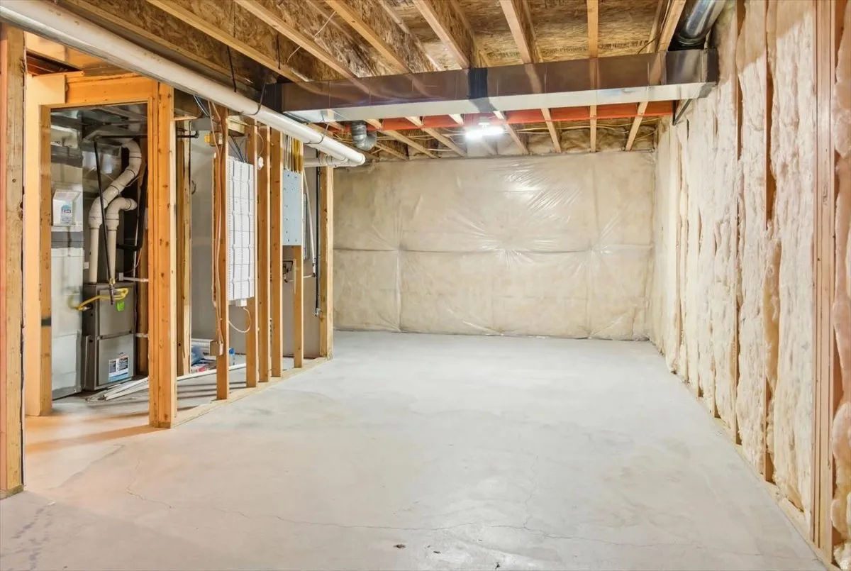 Unfinished basement featuring heating unit