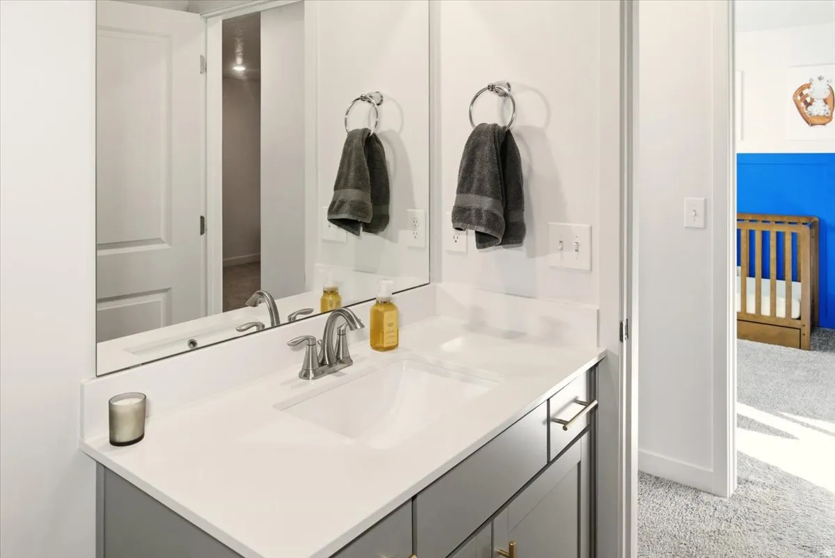 Bathroom featuring vanity and light carpet