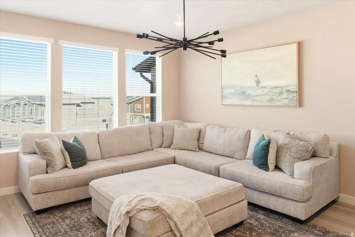 Living area featuring wood finished floors, a textured ceiling, and a chandelier