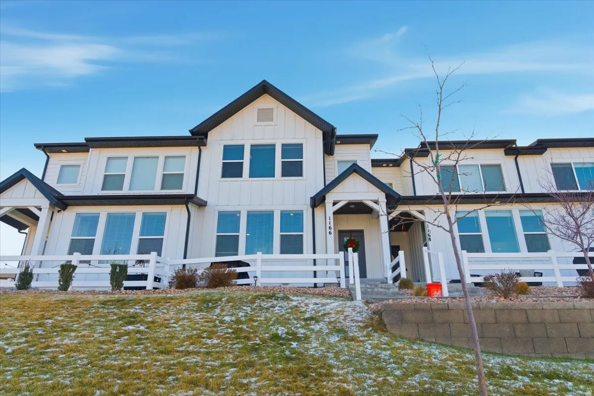 View of front of property with board and batten siding and a fenced front yard
