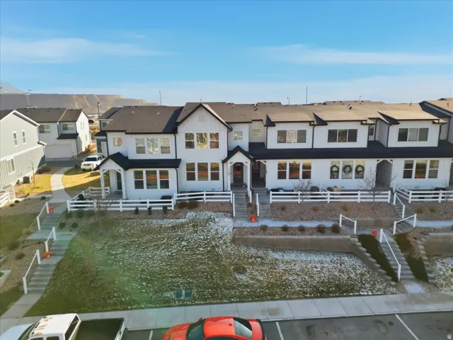 Rear view of house featuring board and batten siding, a residential view, and a fenced front yard