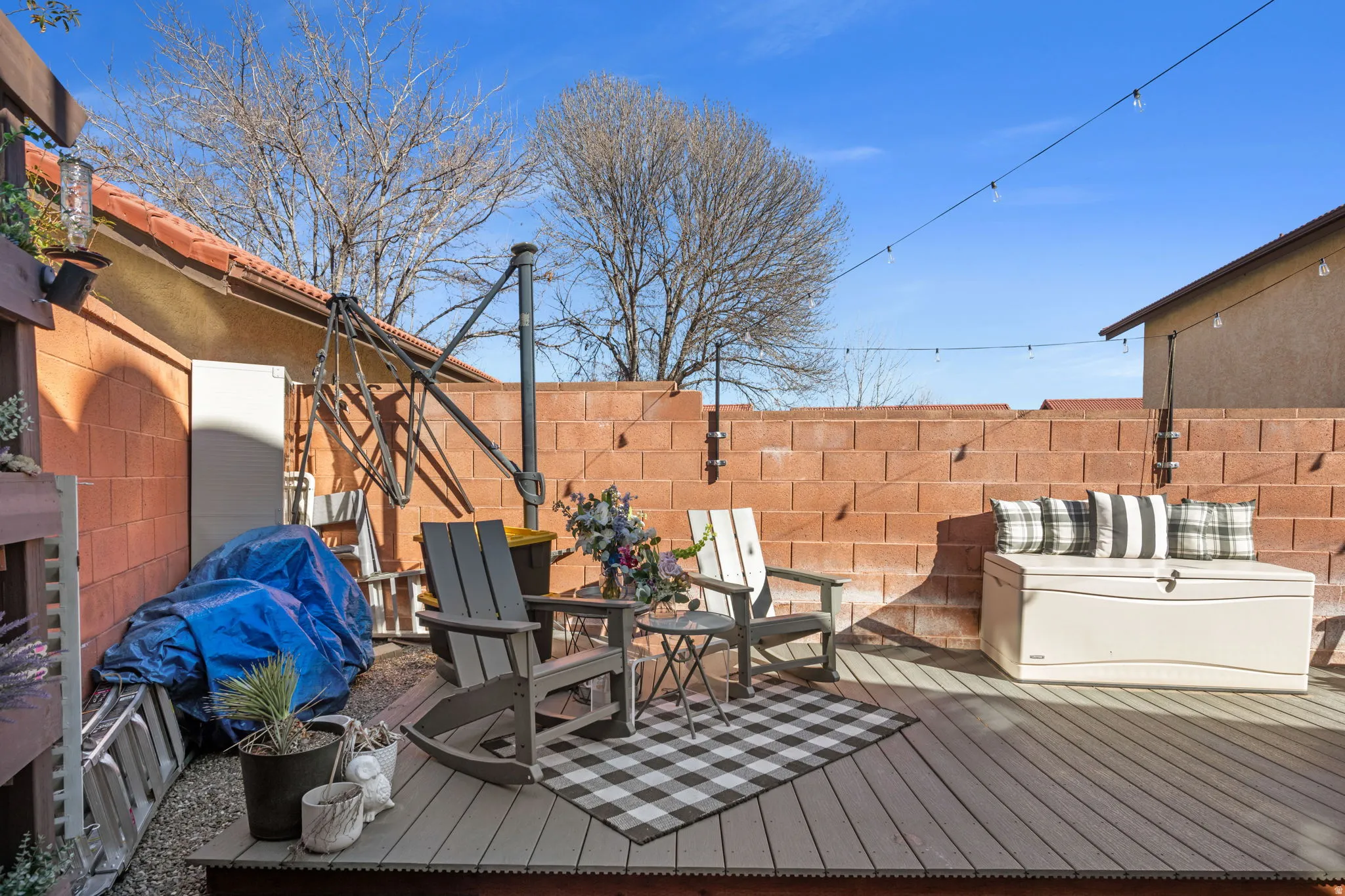 Wooden terrace with a fenced backyard