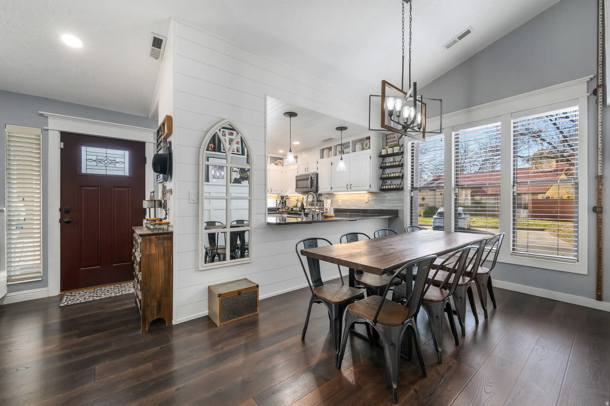 Dining area with dark wood-style floors, lofted ceiling, a chandelier, and recessed lighting