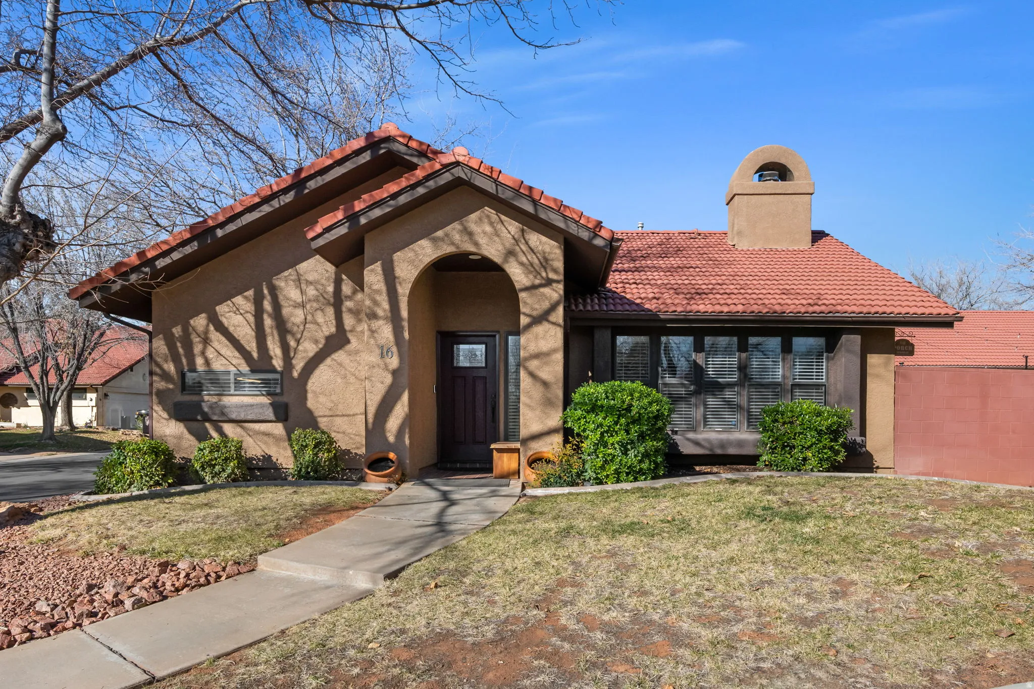 Mediterranean / spanish-style home with a chimney, a tiled roof, and stucco siding
