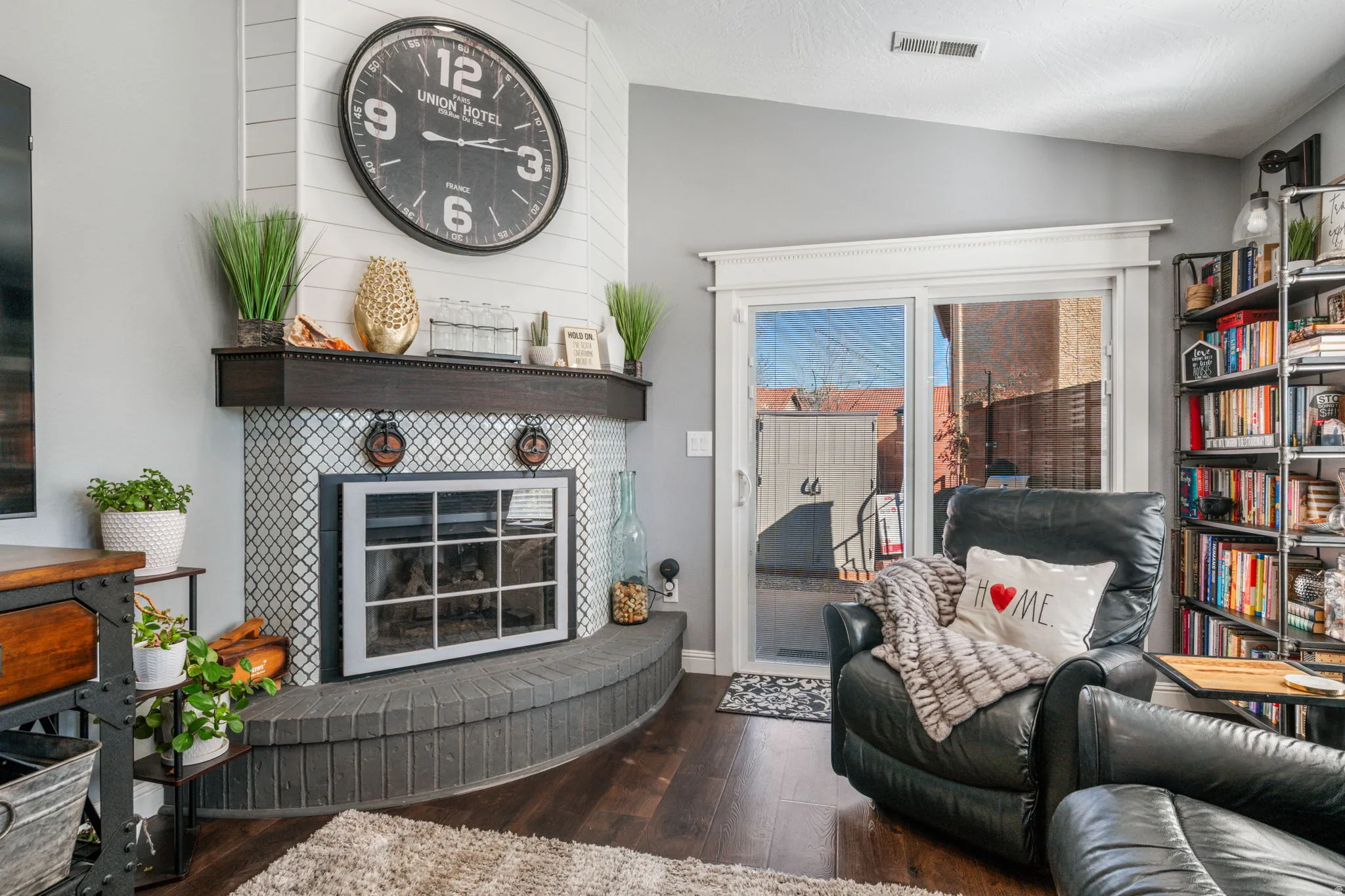 Living room featuring vaulted ceiling, a fireplace, and dark wood-type flooring