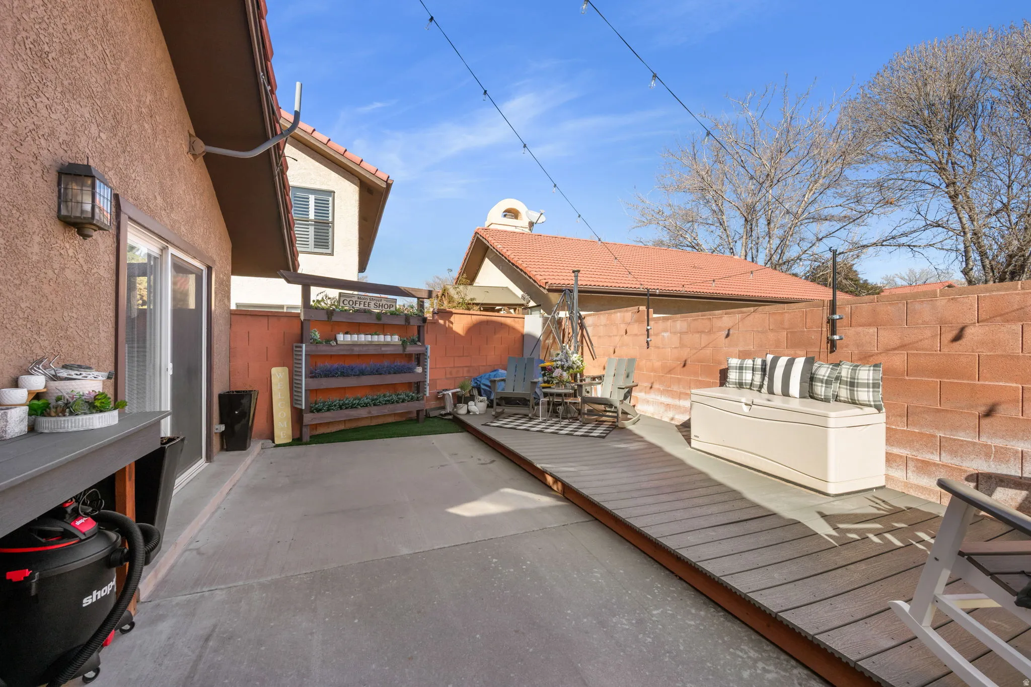 Fenced backyard with a wooden deck and a patio area