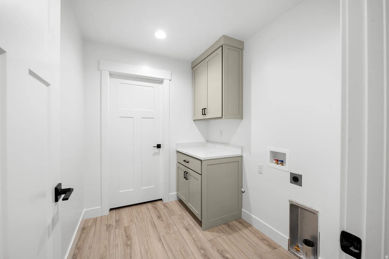 Laundry room with cabinet space, light wood-style flooring, washer hookup, and recessed lighting