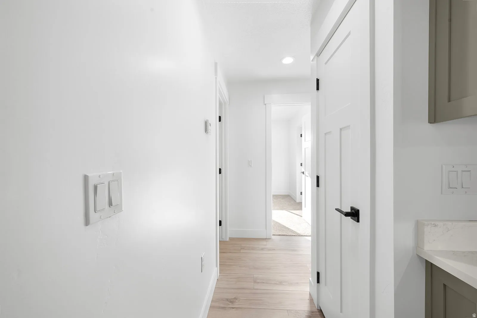Corridor featuring light wood-type flooring and recessed lighting