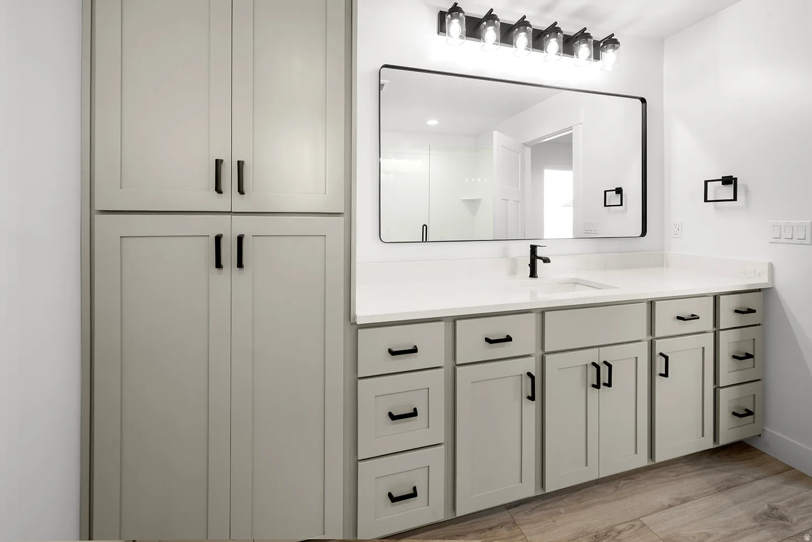 Full bathroom featuring vanity, light wood-type flooring, and a shower stall
