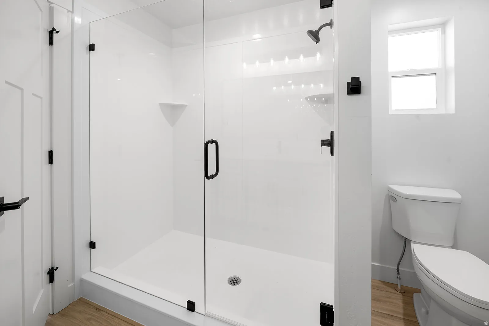 Full bathroom with a stall shower and light wood-style flooring