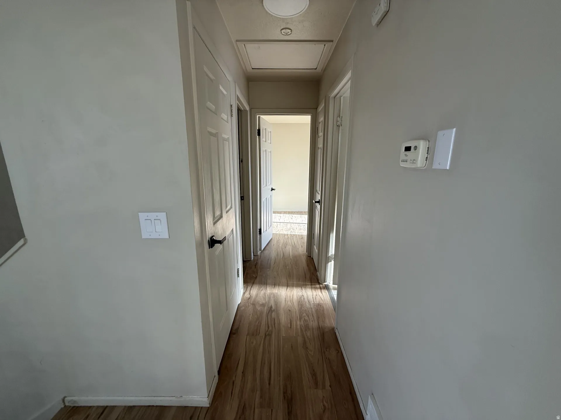 Hallway with dark wood finished floors and baseboards