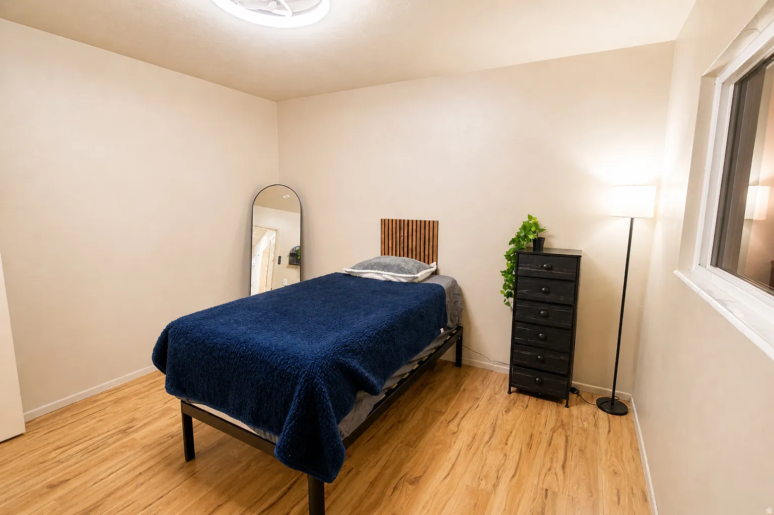 Bedroom with light wood finished floors and baseboards