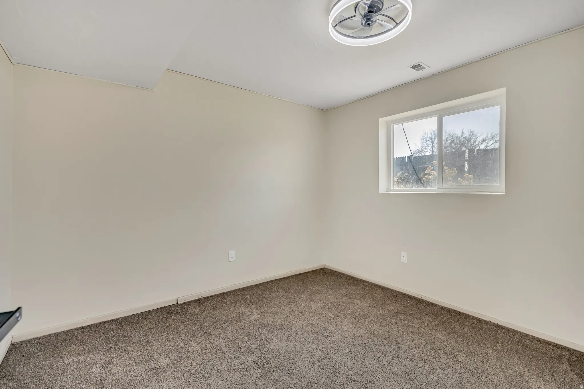 Carpeted spare room with baseboards