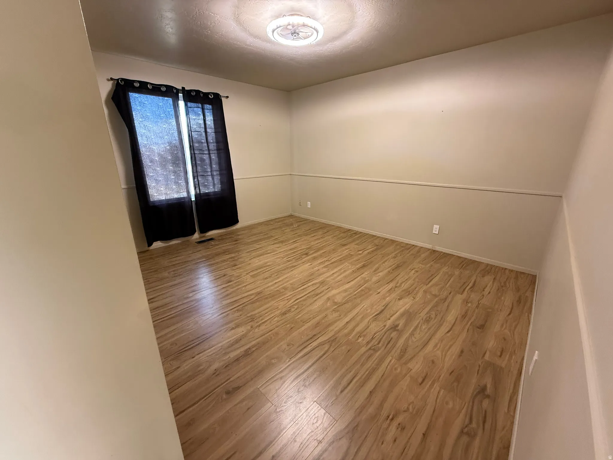 Unfurnished room featuring wood finished floors and baseboards