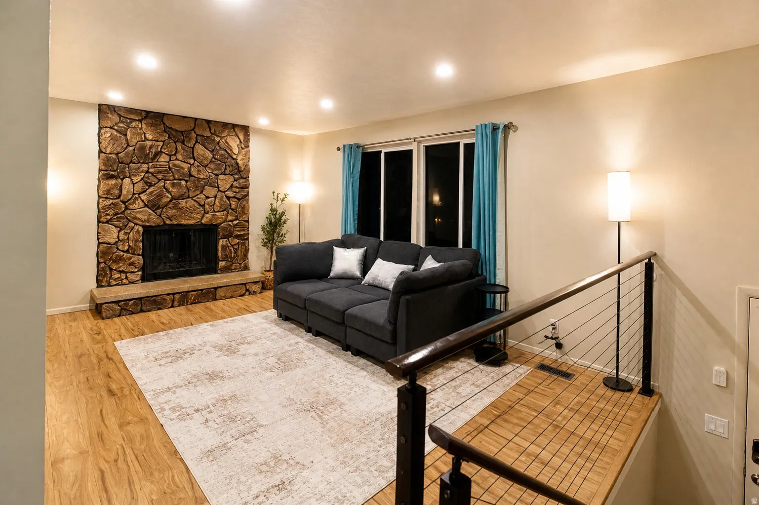 Living room featuring a fireplace, light wood finished floors, and recessed lighting