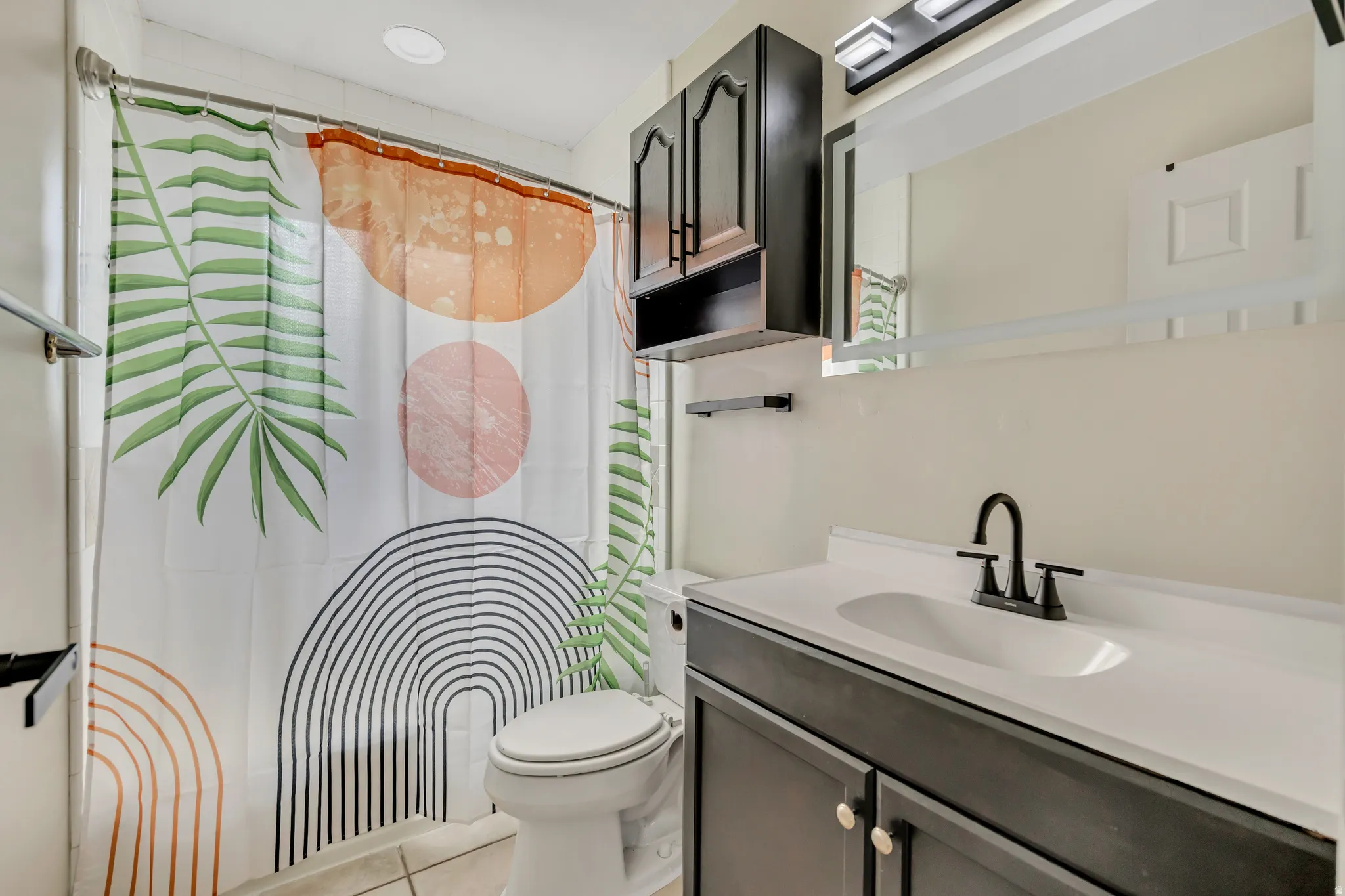 Full bathroom with vanity and light tile floor