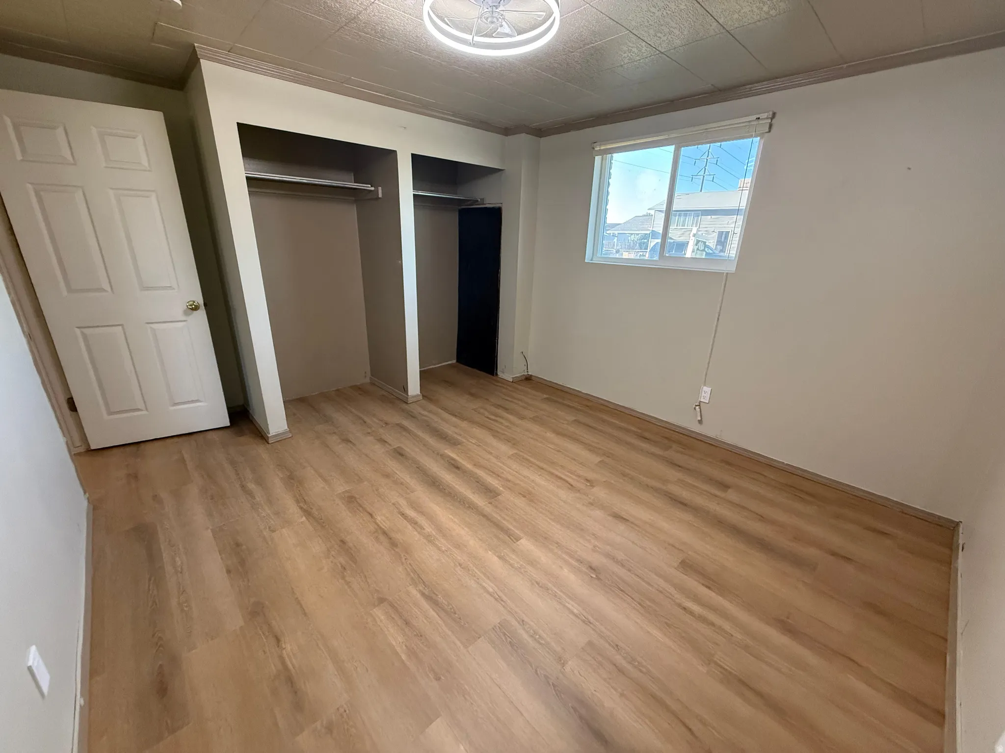 Room featuring wood-finish flooring, neutral wall tones, and a paneled door