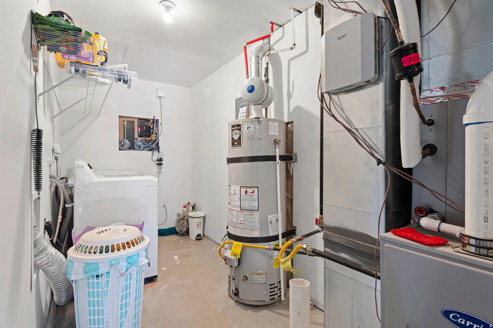 Utility room featuring heating unit and water heater