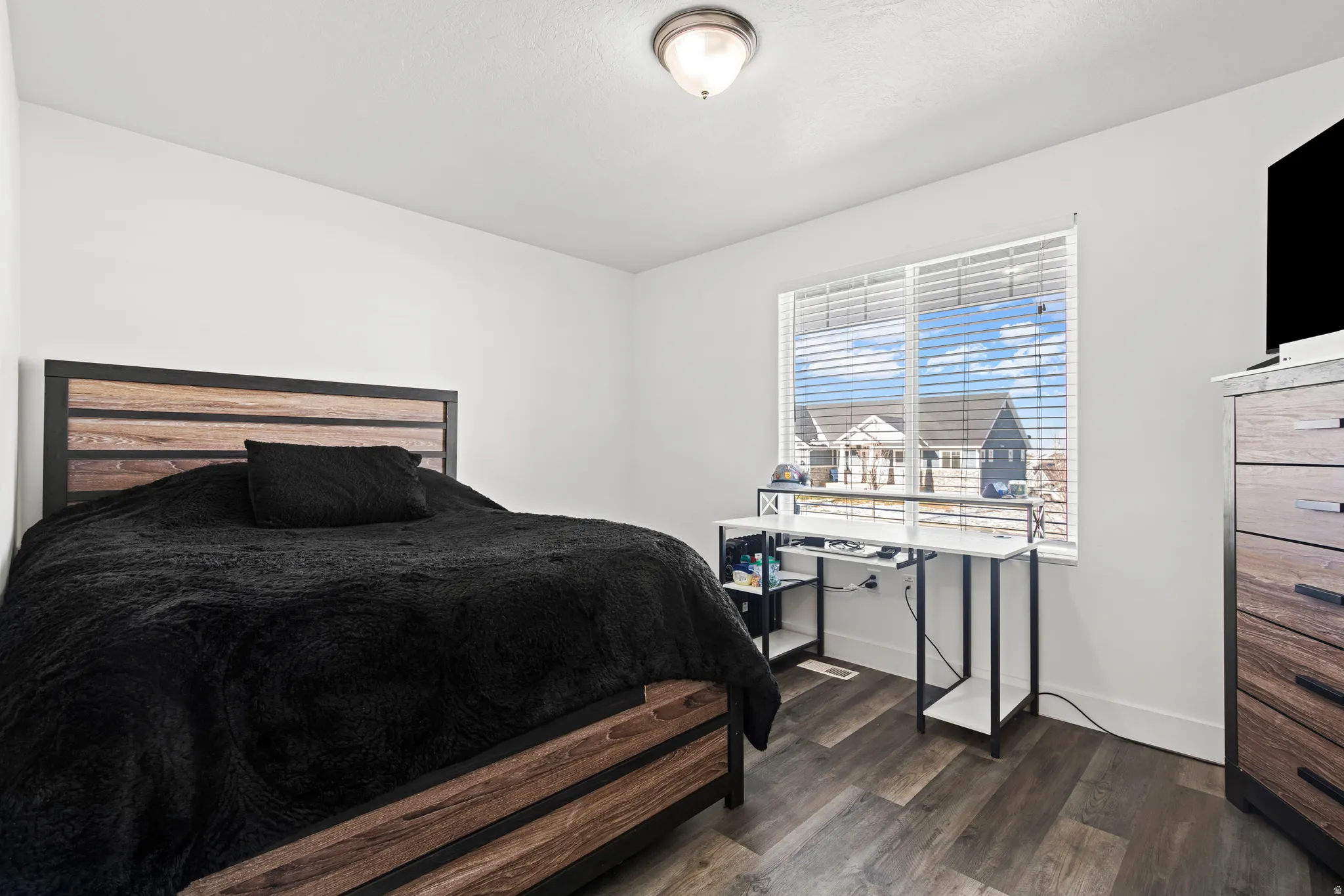 Bedroom featuring dark wood-style floors and baseboards