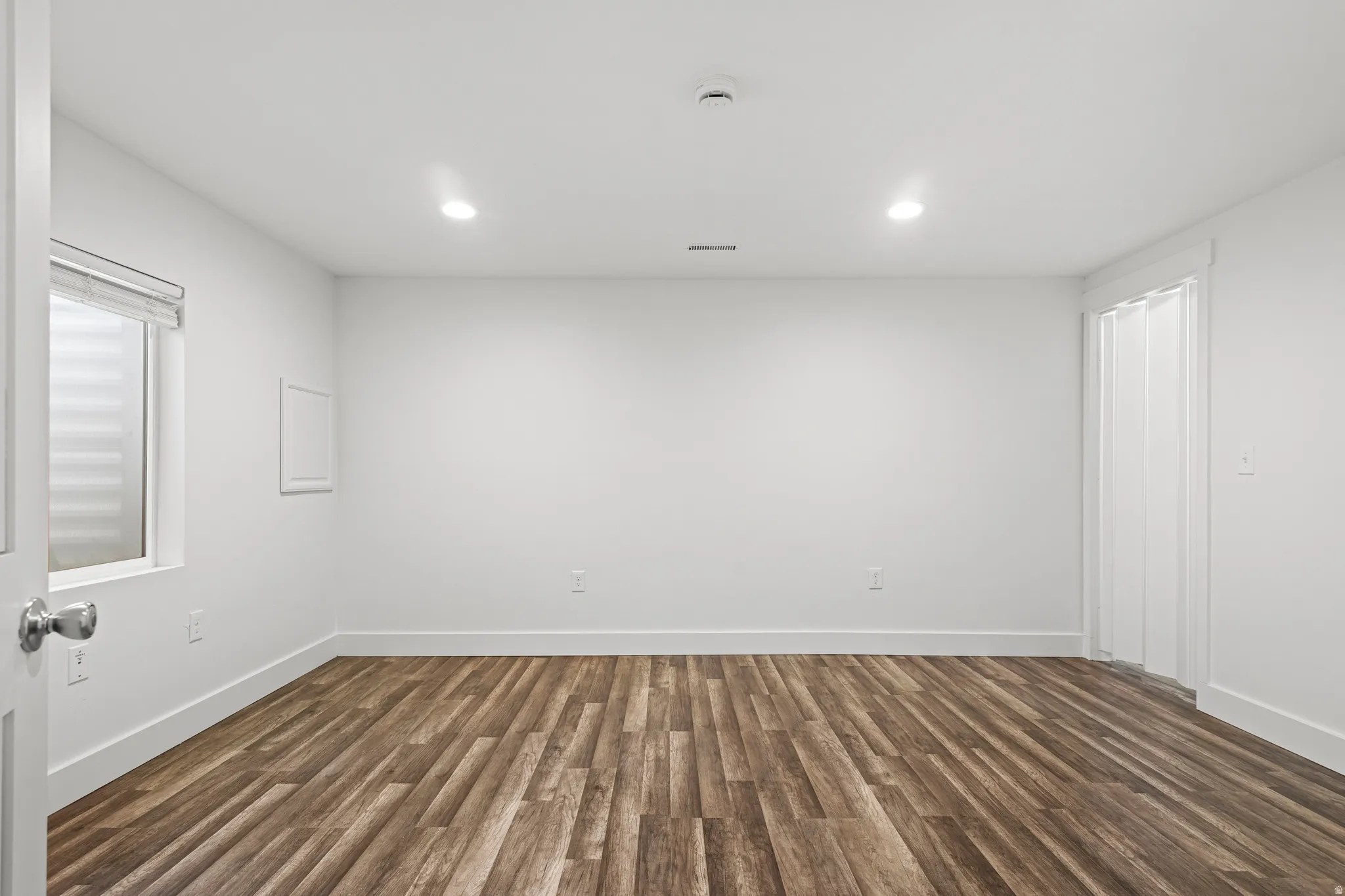 Spare room featuring dark wood-style floors and recessed lighting