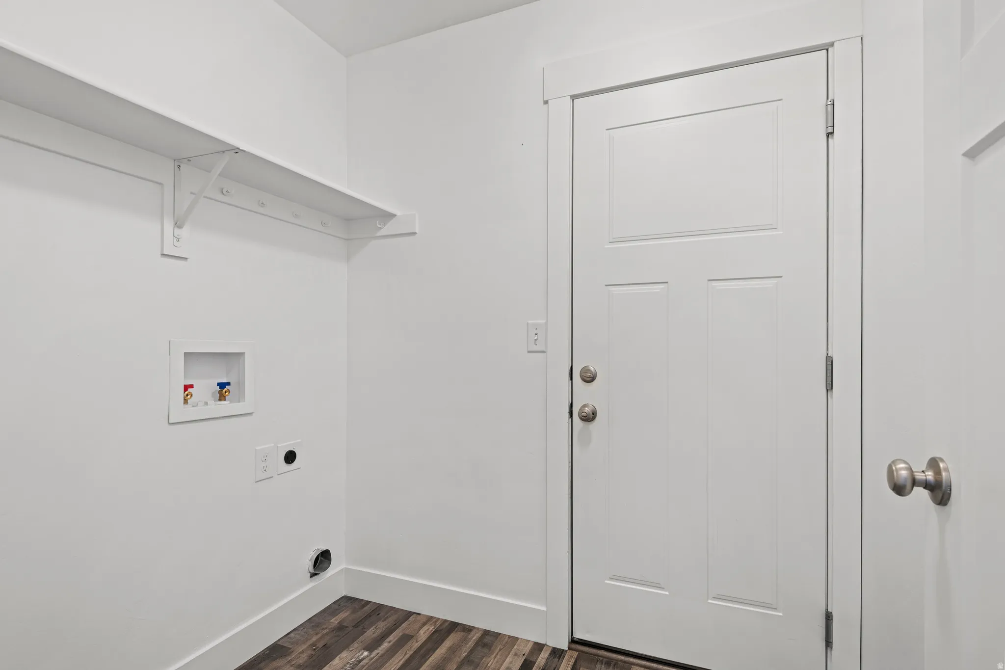 Laundry area featuring dark wood-type flooring, hookup for a washing machine, and electric dryer hookup