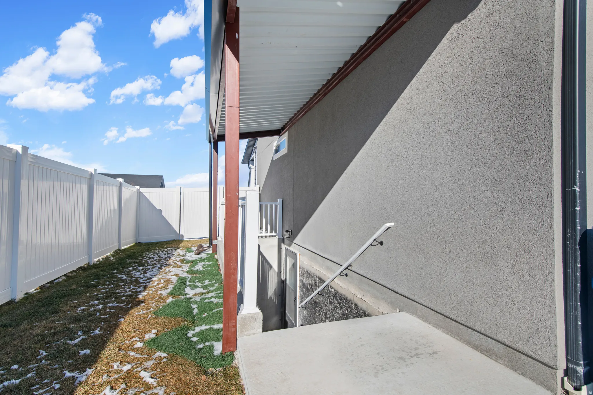 View of side of home with stucco siding, a fenced backyard, and a patio