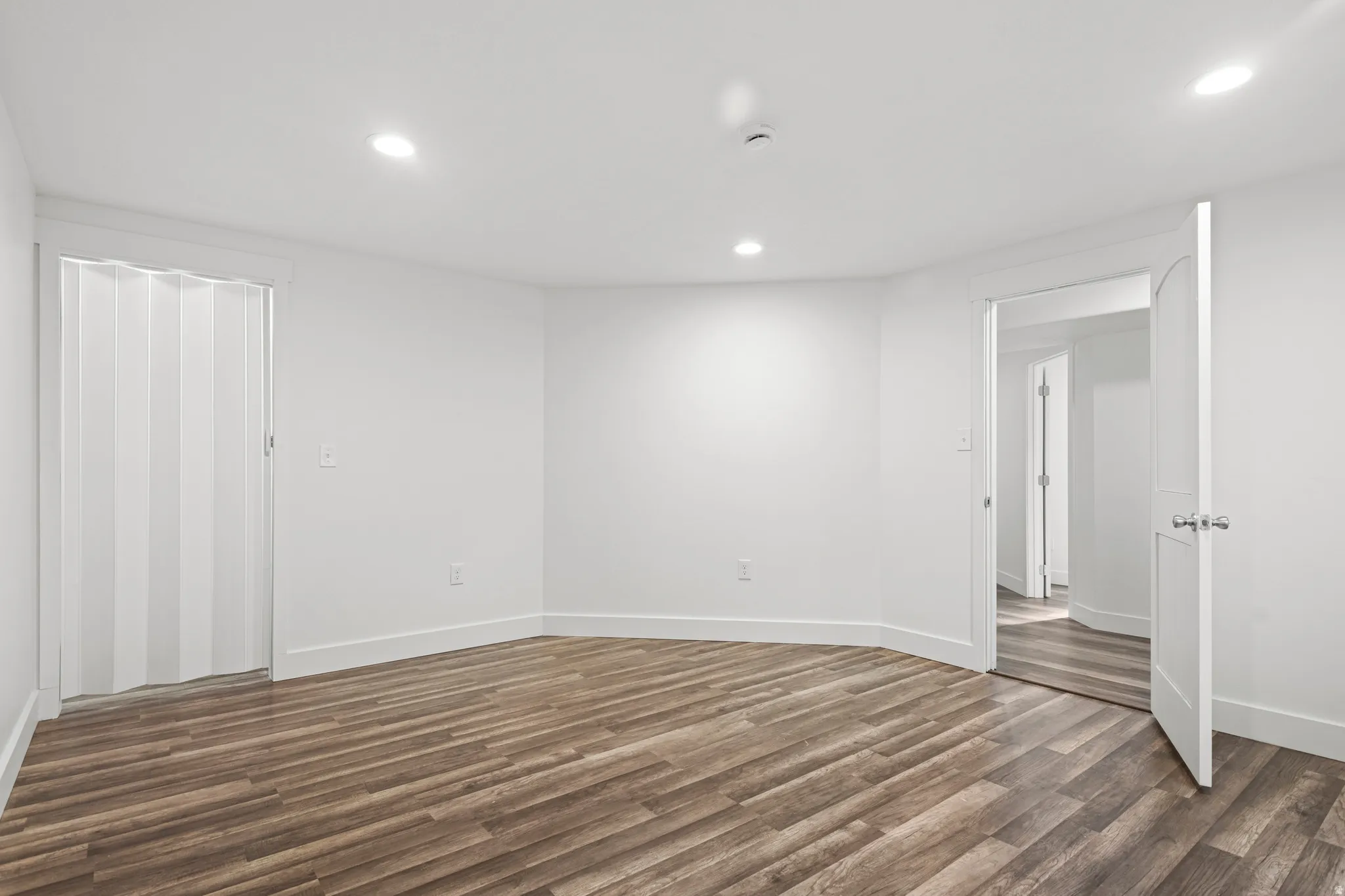Spare room with dark wood finished floors and recessed lighting