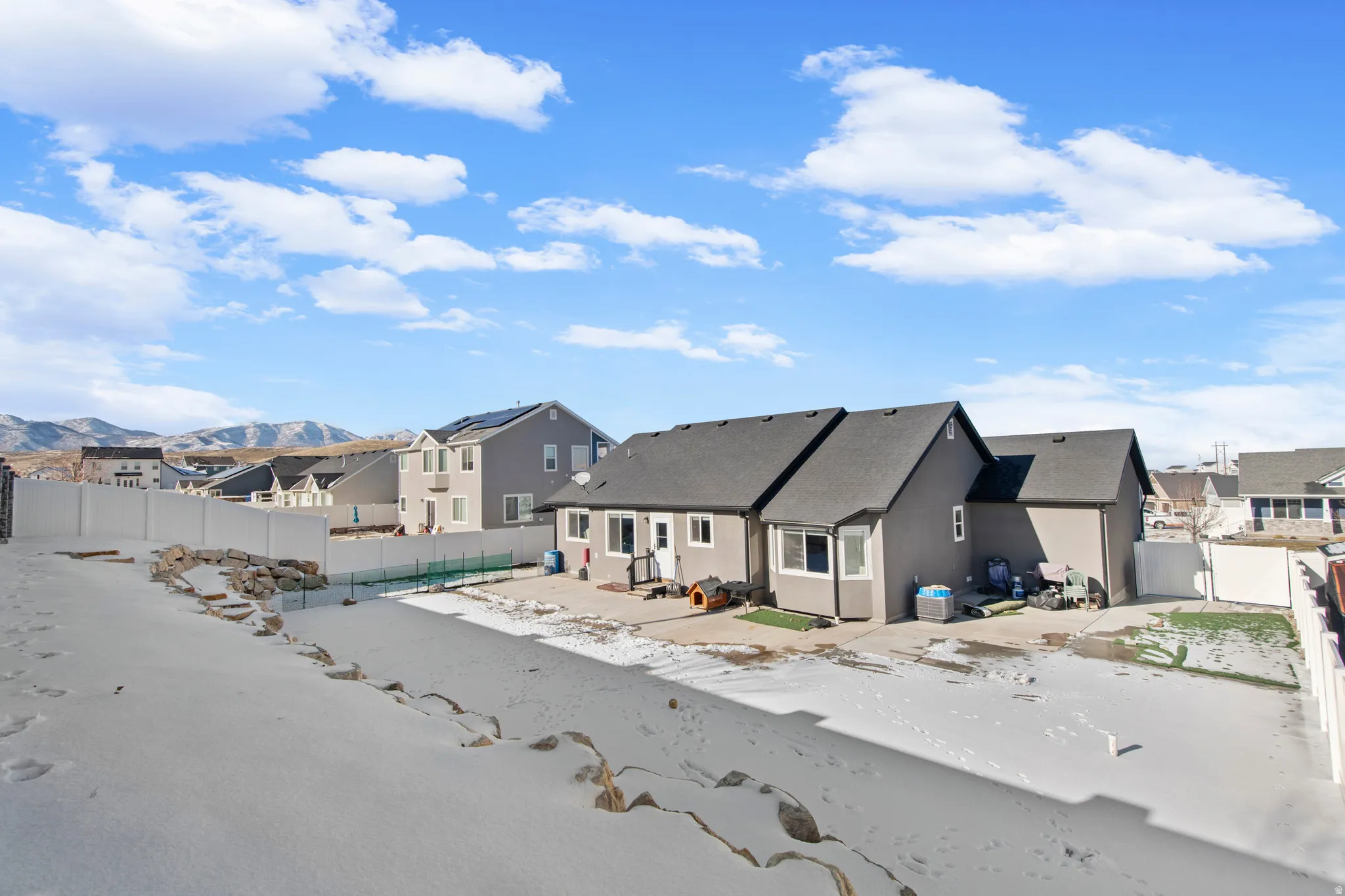 View of front of home with a fenced backyard, a residential view, a patio area, a mountain view, and stucco siding