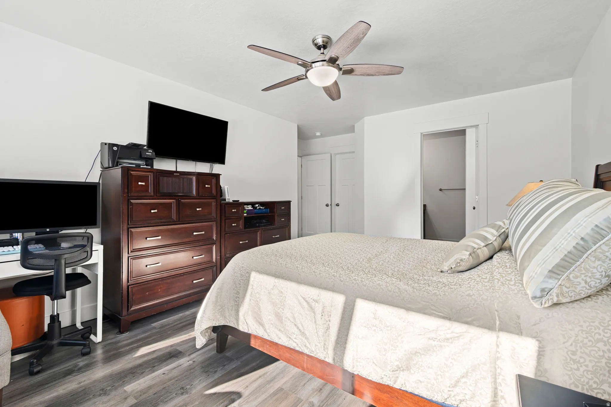 Bedroom with dark wood-style flooring, a ceiling fan, and a desk