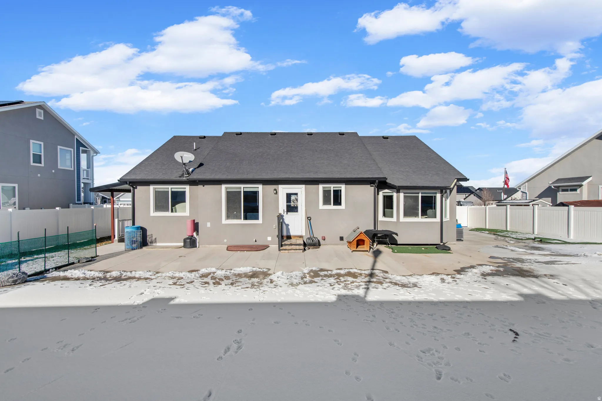 Rear view of house with a fenced backyard, a patio area, stucco siding, and a shingled roof