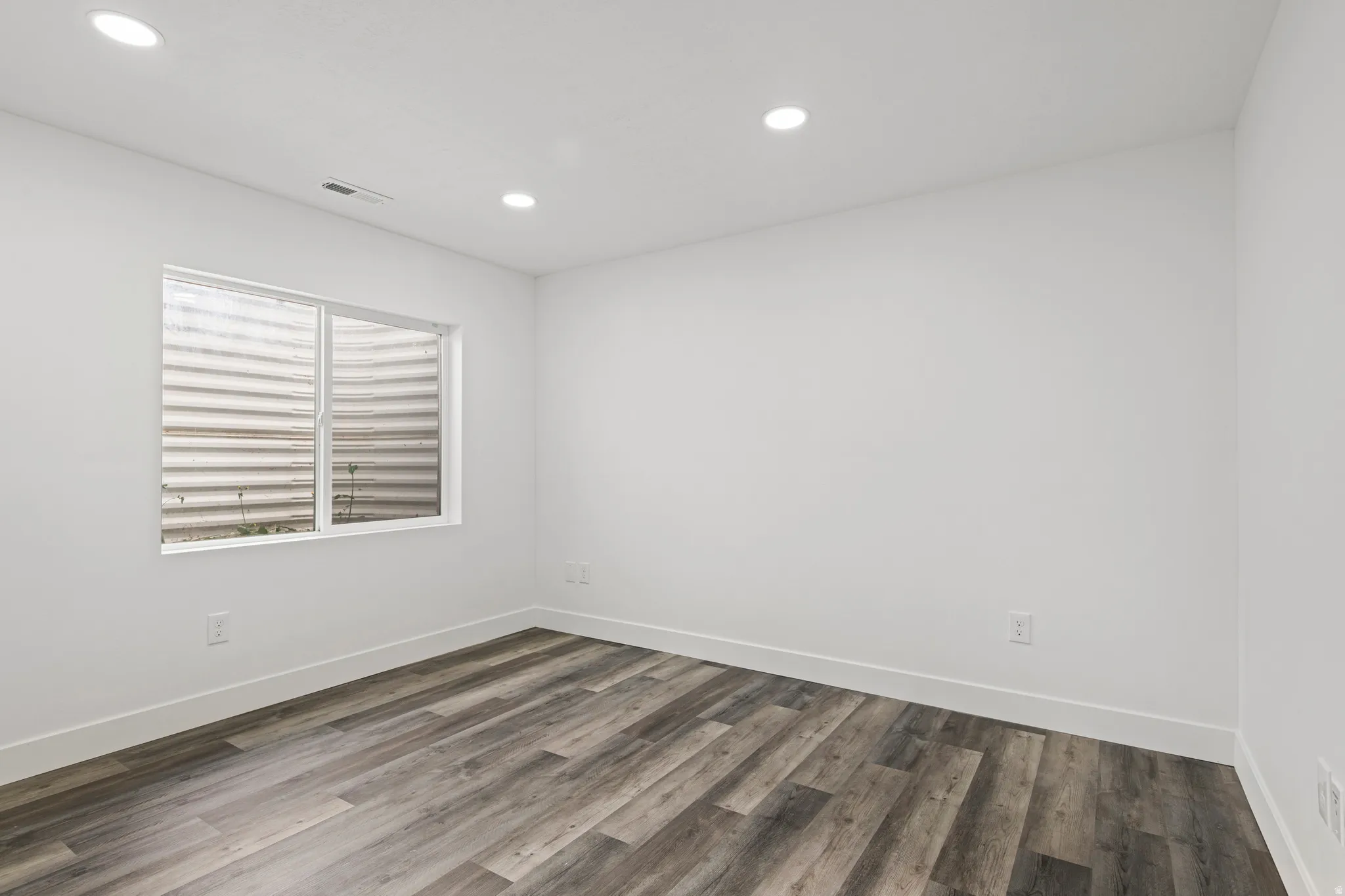Empty room featuring wood finished floors and recessed lighting