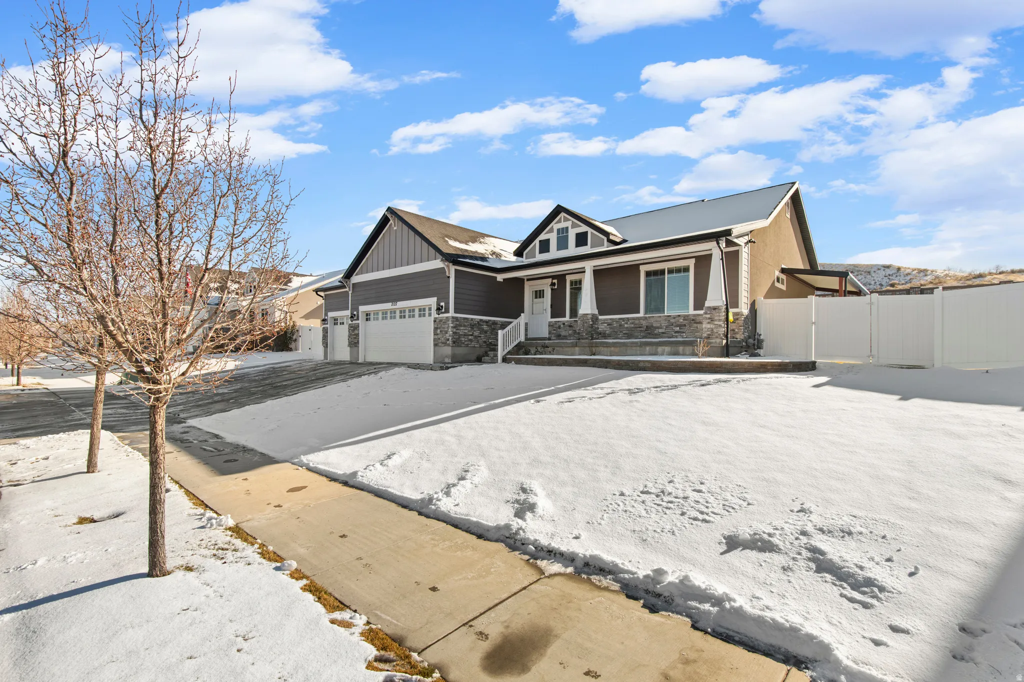 Craftsman-style house with stone siding, an attached garage, and a porch
