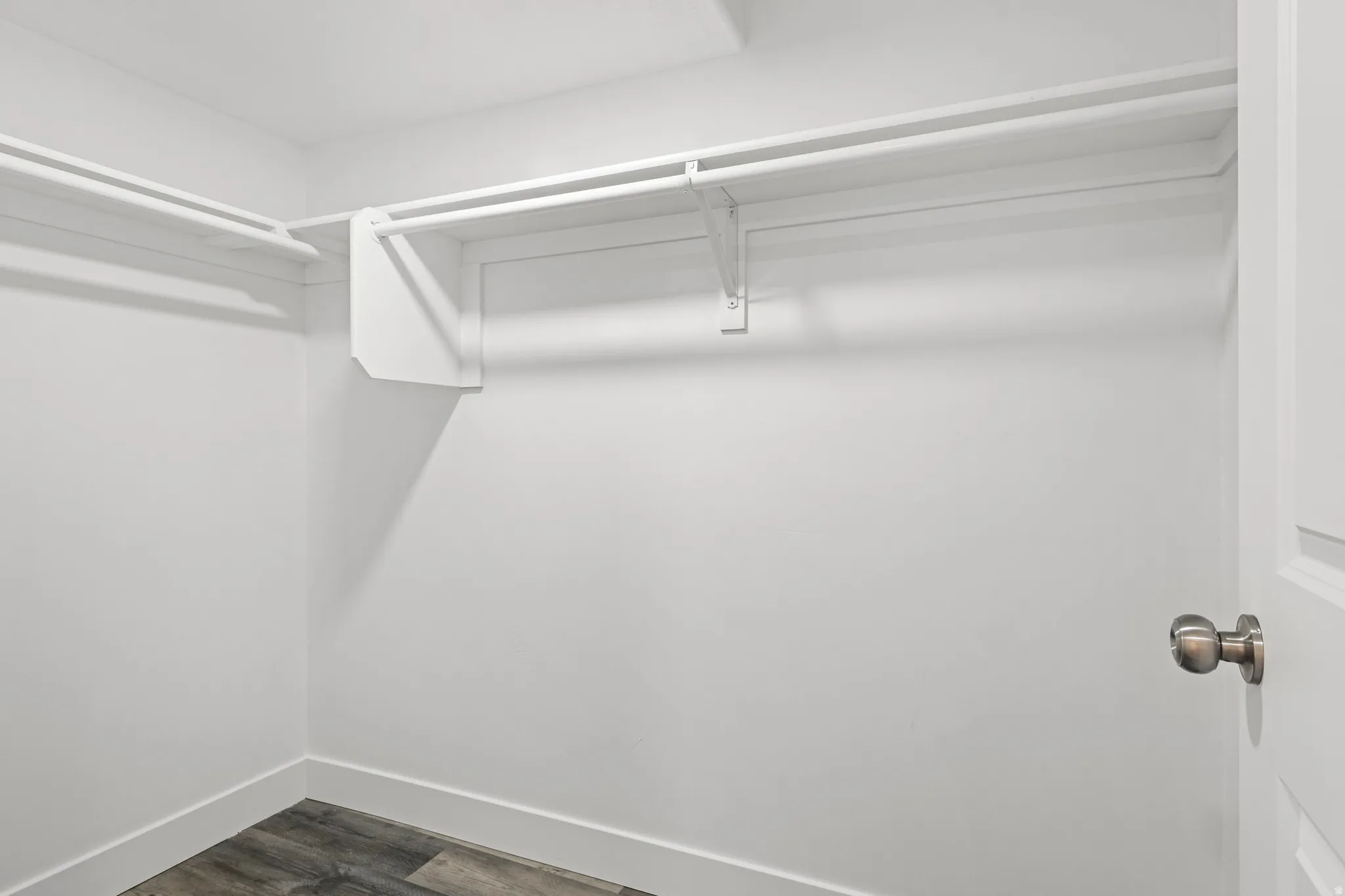Spacious closet with dark wood-style flooring
