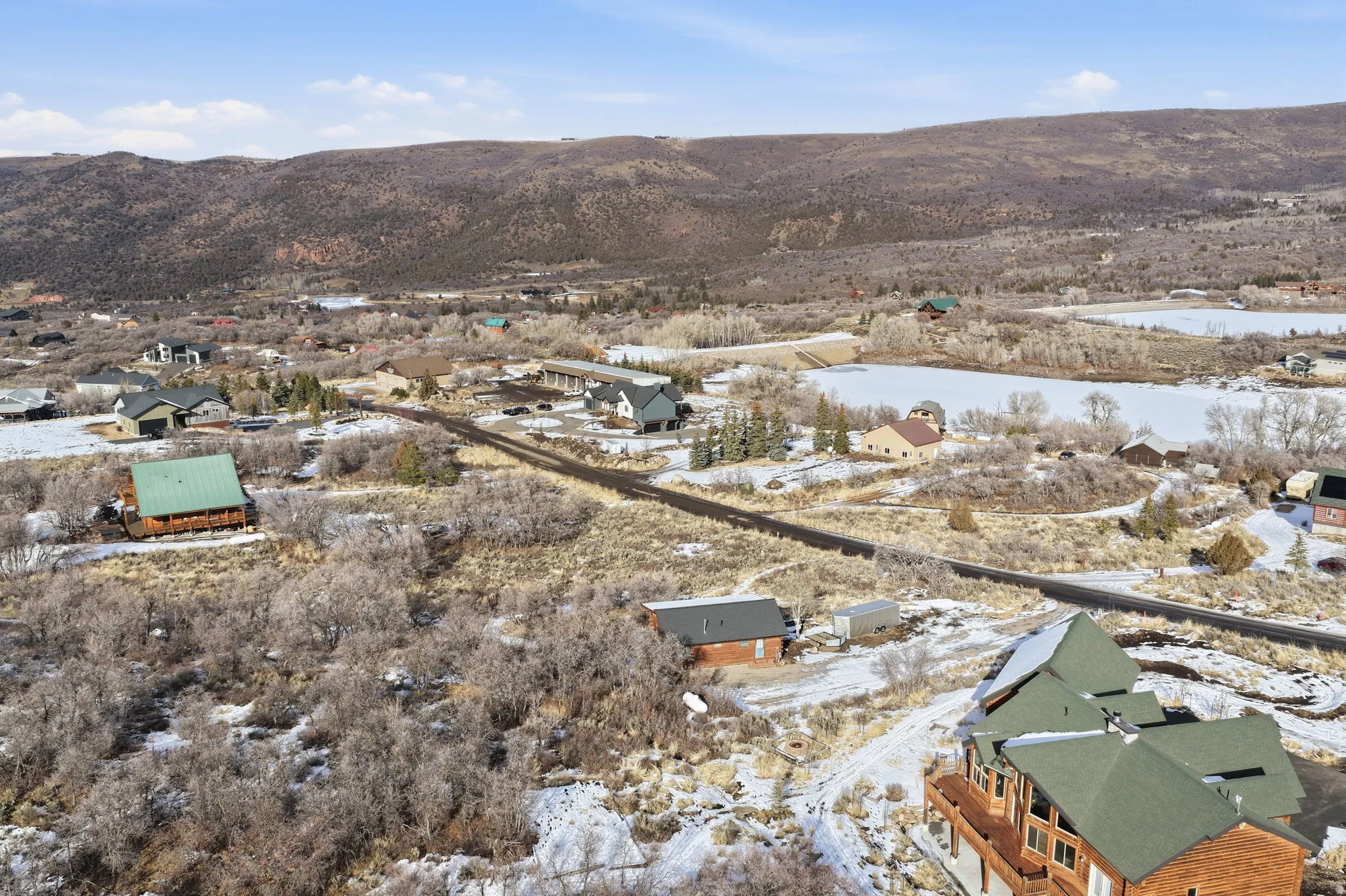 Snowy aerial view featuring a residential view and a mountain view