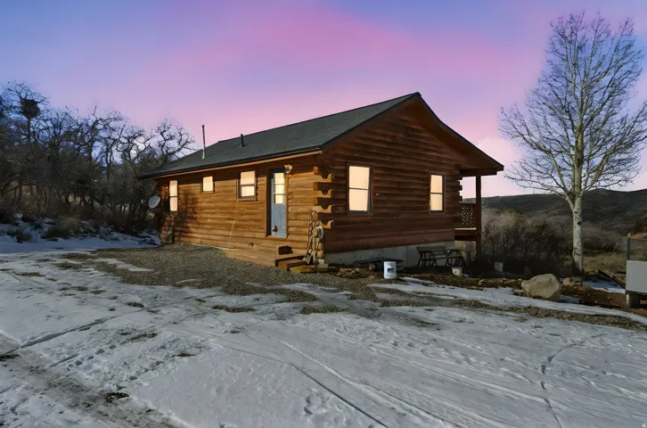 Snow covered property with log siding