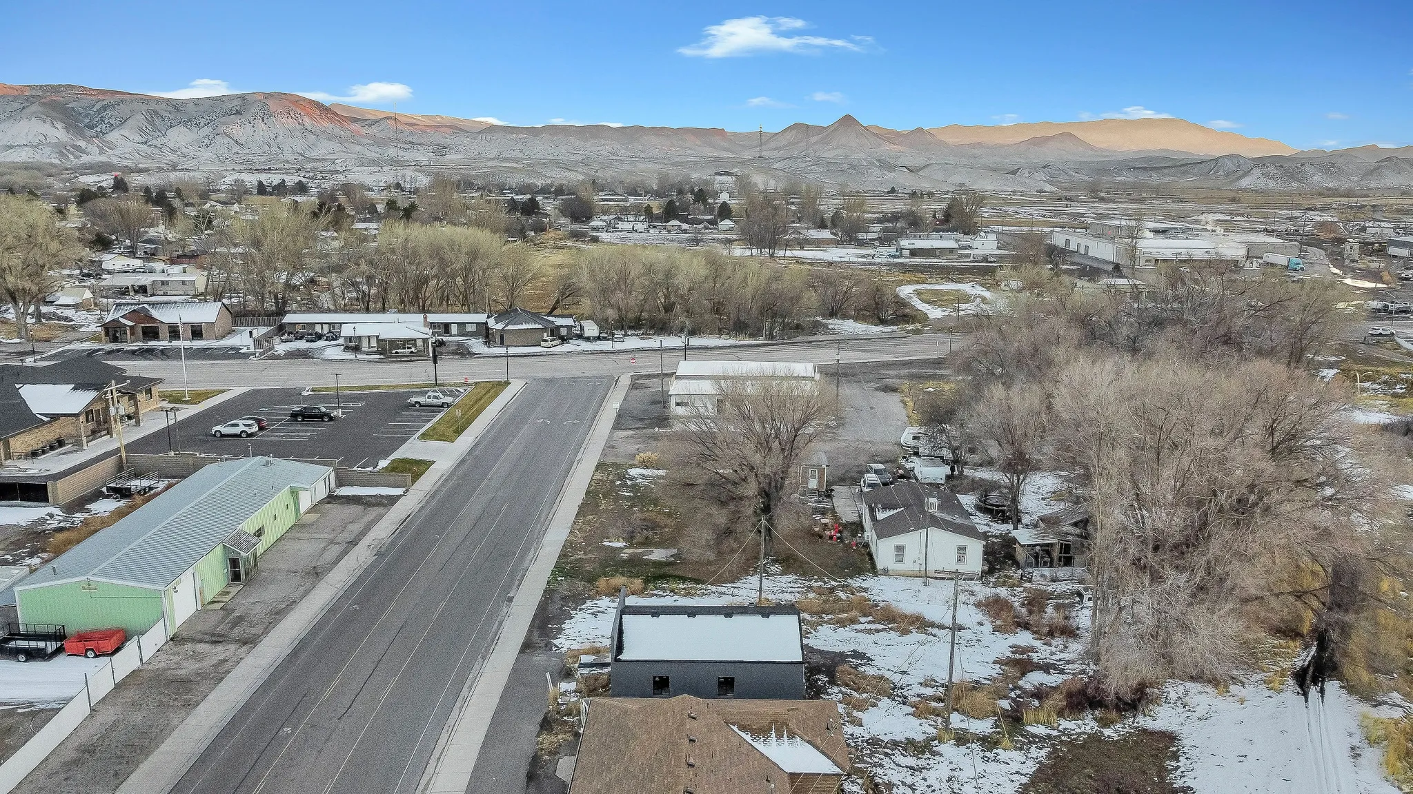 Snowy aerial view featuring a mountain view and a residential view