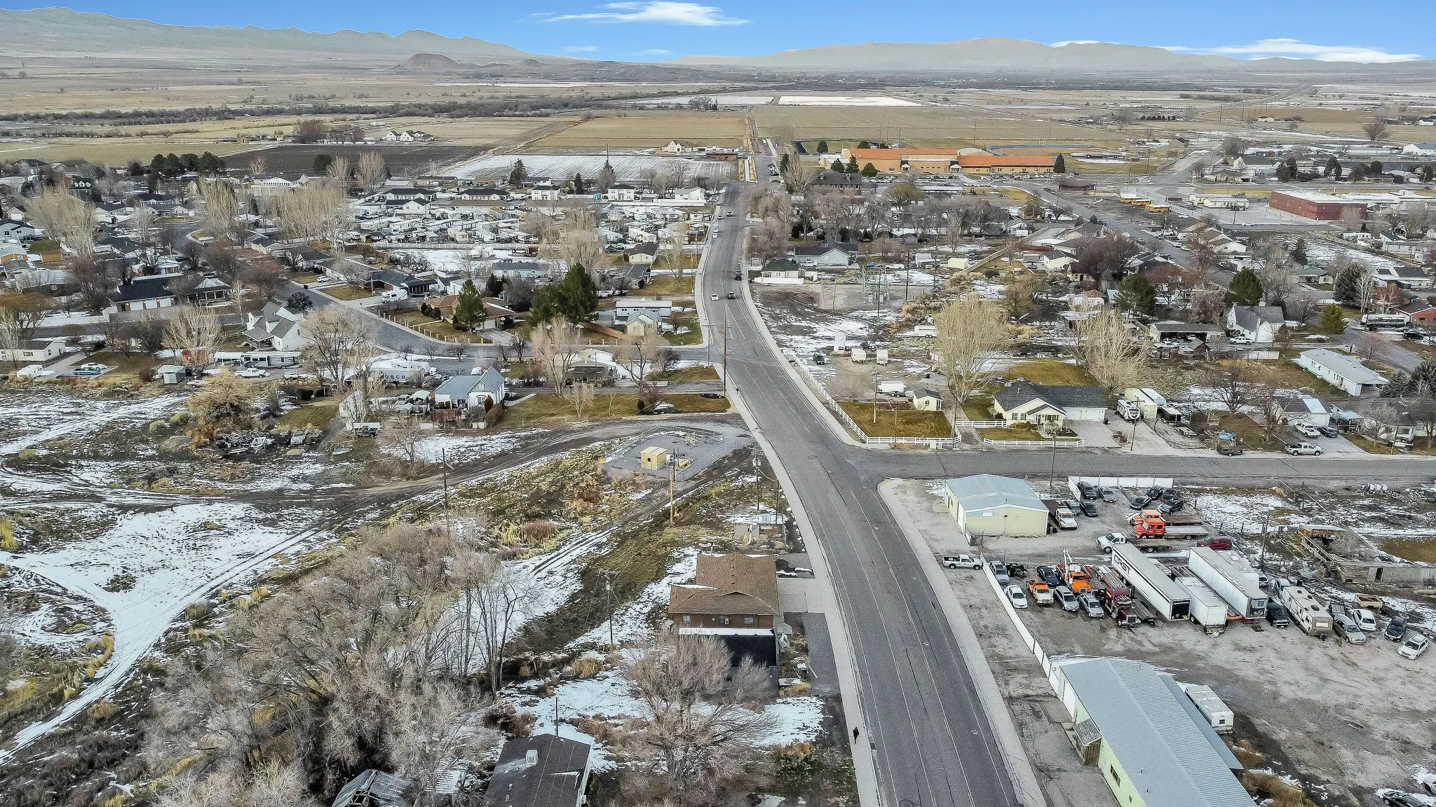 Snowy aerial view with a mountain view and a residential view