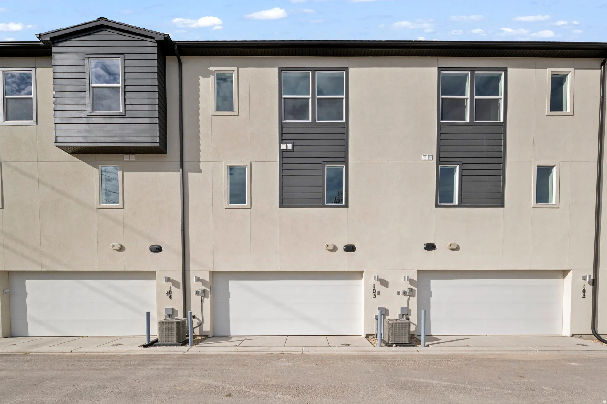 Rear view of house featuring stucco siding and a garage