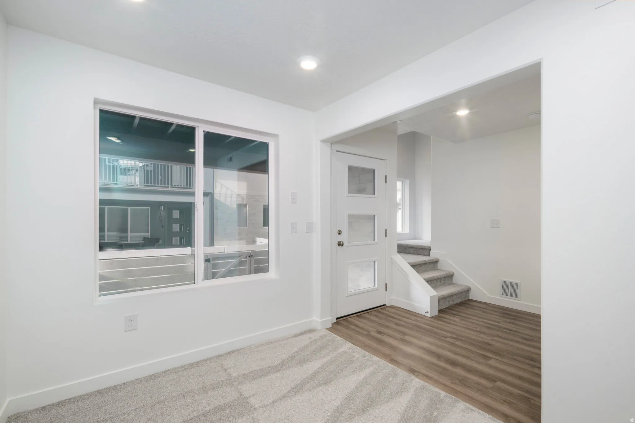 Foyer with stairway, wood finished floors, and recessed lighting