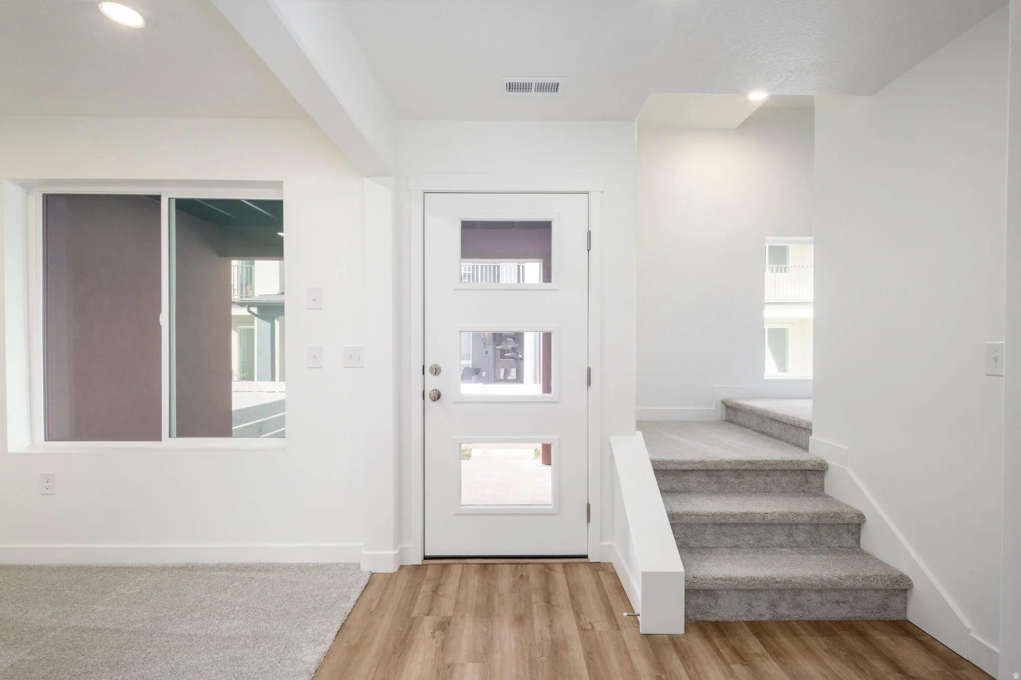 Foyer entrance featuring light wood-style floors, stairs, and recessed lighting