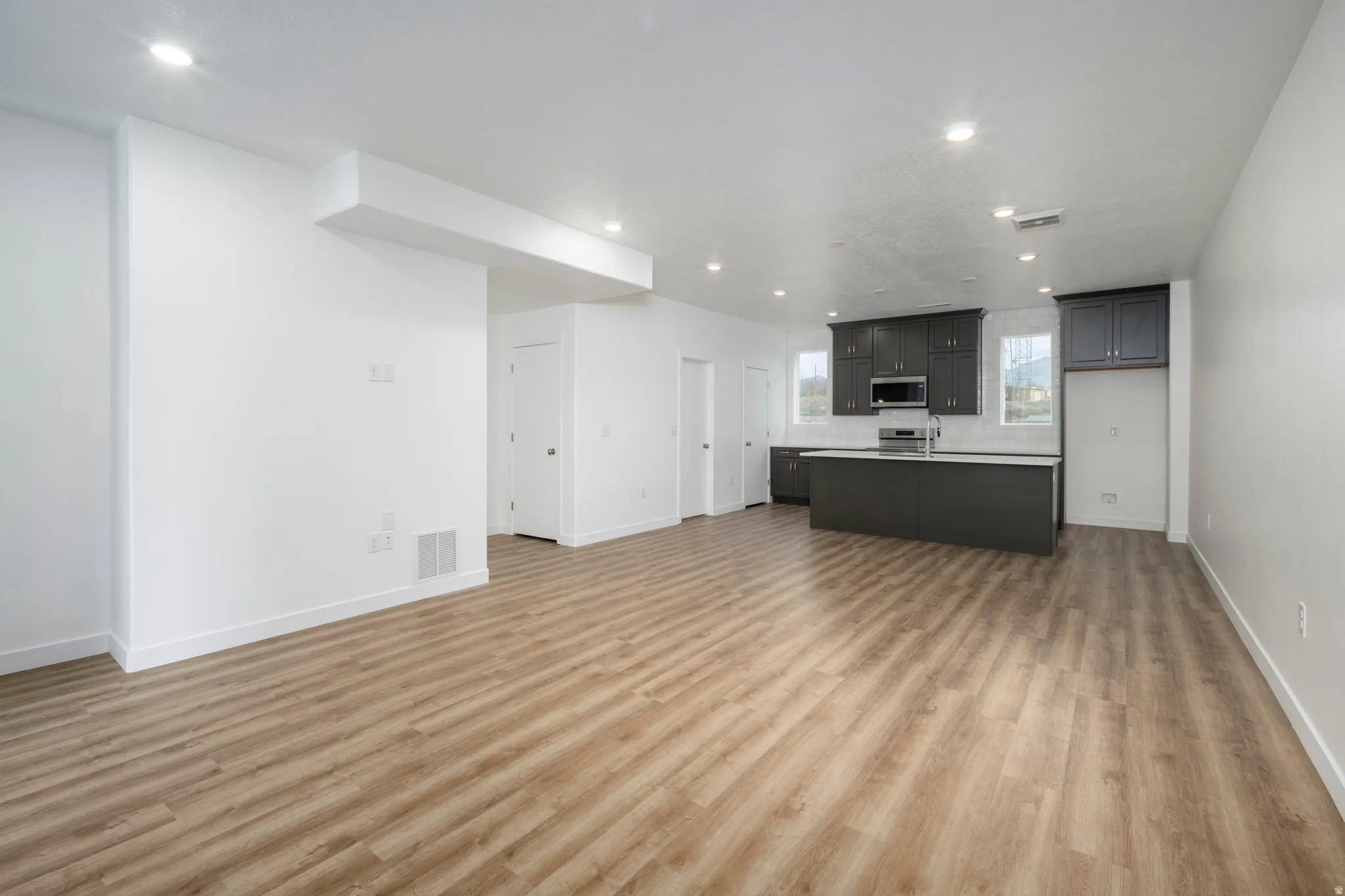 Unfurnished living room with light wood-type flooring and recessed lighting