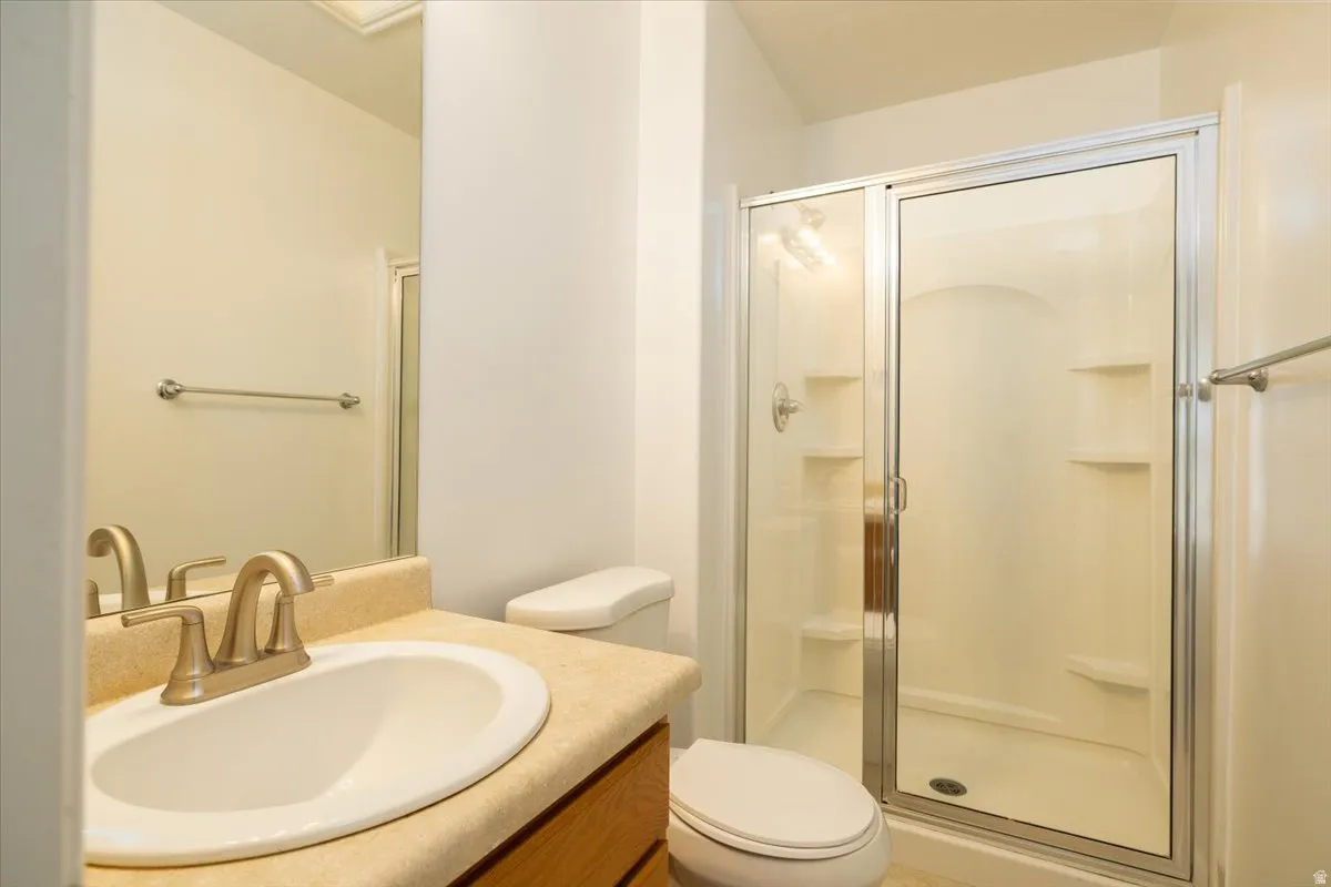 Primary bedroom bathroom featuring vanity and a stall shower