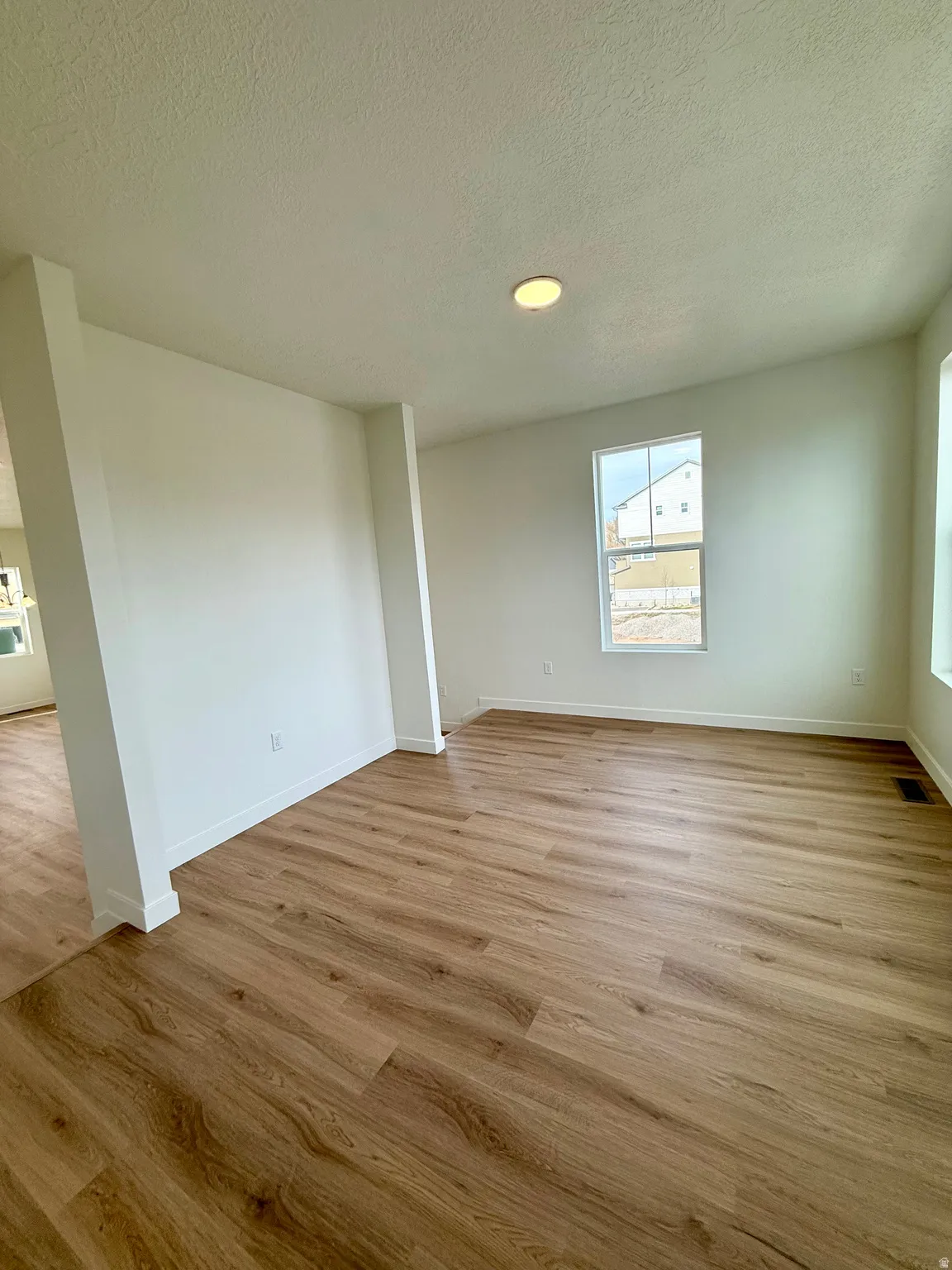 Spare room featuring light wood-style floors and a textured ceiling