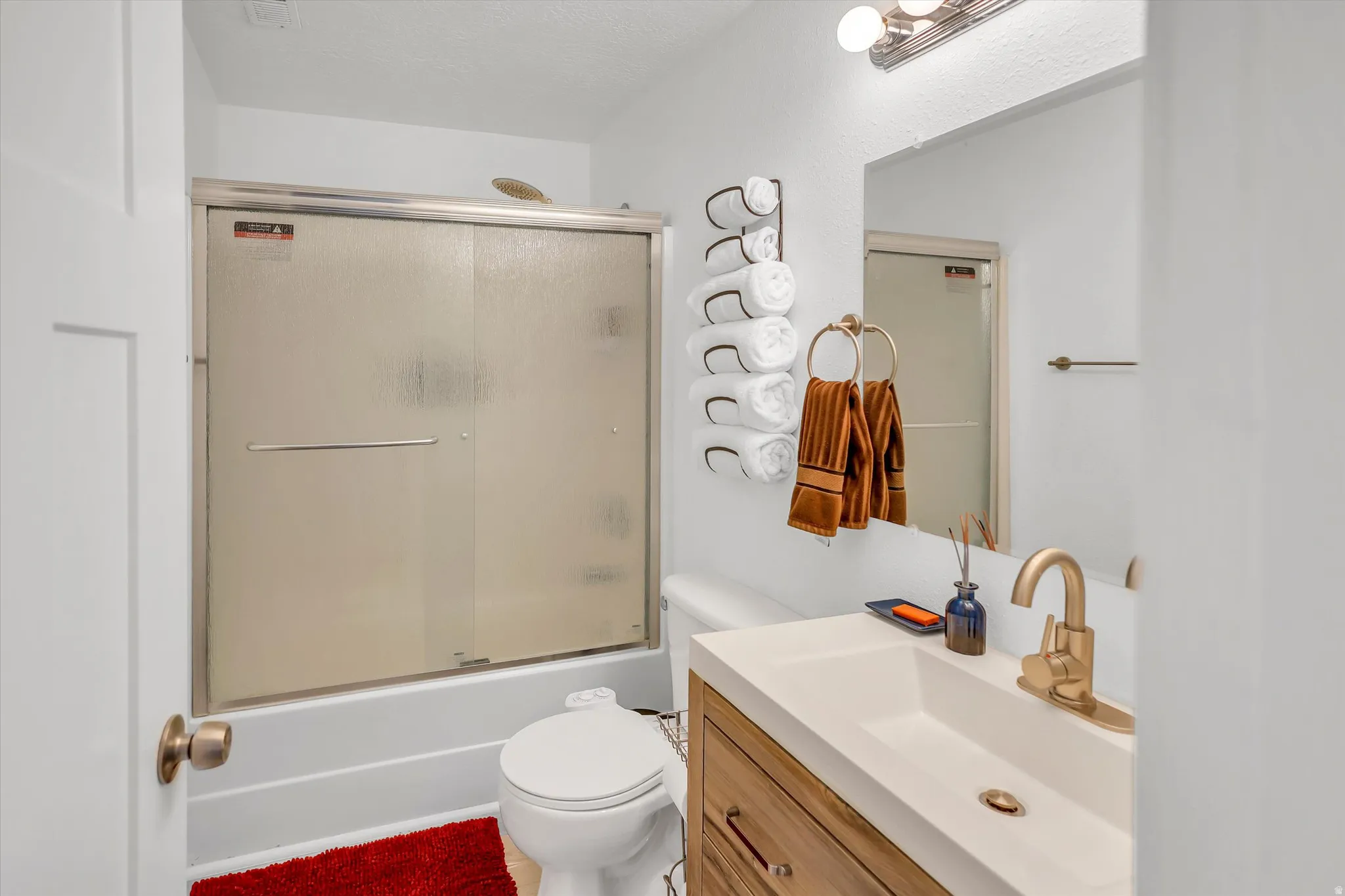 Bathroom with vanity and combined bath / shower with glass door