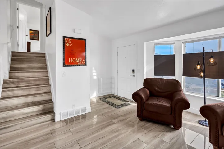 Entrance foyer with stairway and wood tiled floors
