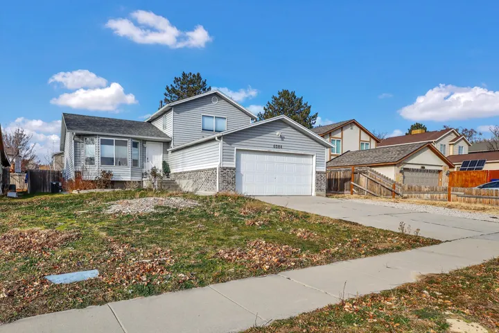 View of front of property with brick siding, concrete driveway, and an attached garage