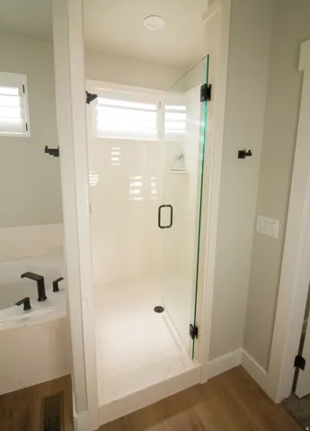 Master bathroom with a shower stall, wood finished floors, and a garden tub