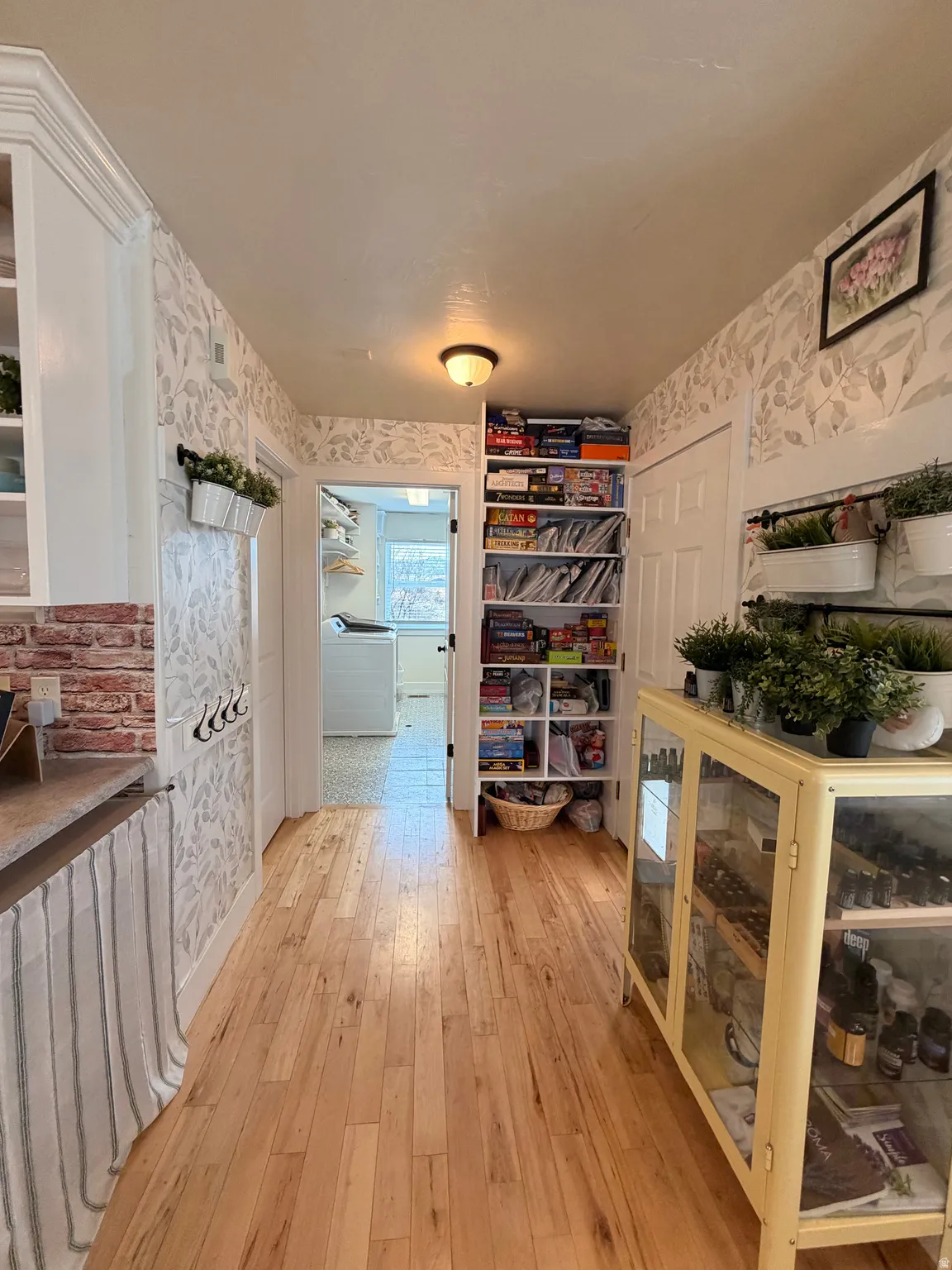 Hallway featuring wallpapered walls and light wood-type flooring