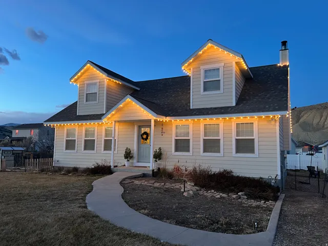 View of front of house featuring a chimney and a shingled roof