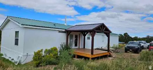Rear view of property featuring a deck and a metal roof